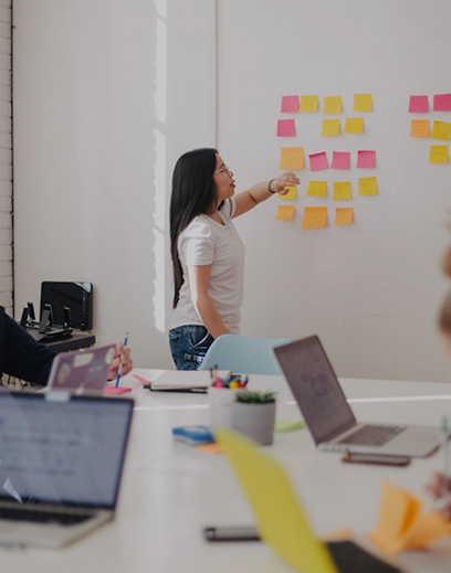 Researchers with sticky notes on whiteboard